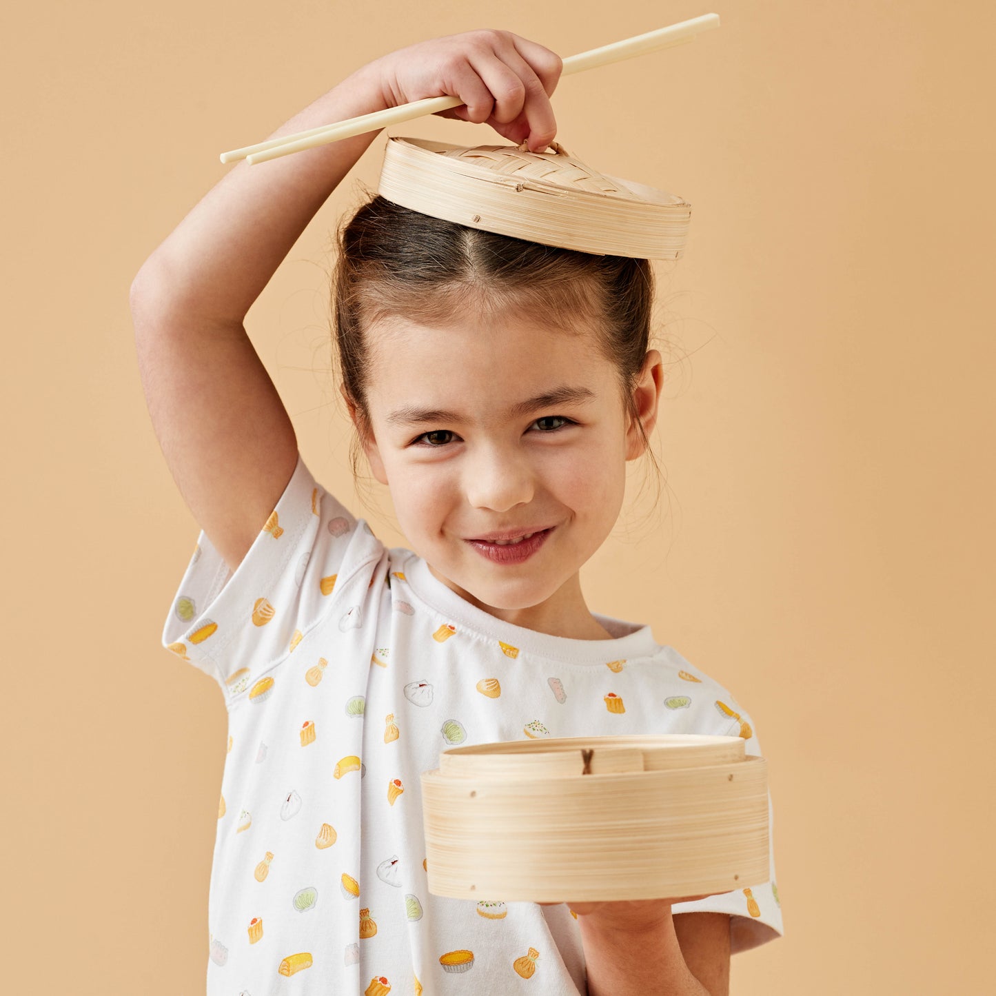 Girl wearing a colourful Dim Sum kids tshirt with a steamer bun basket