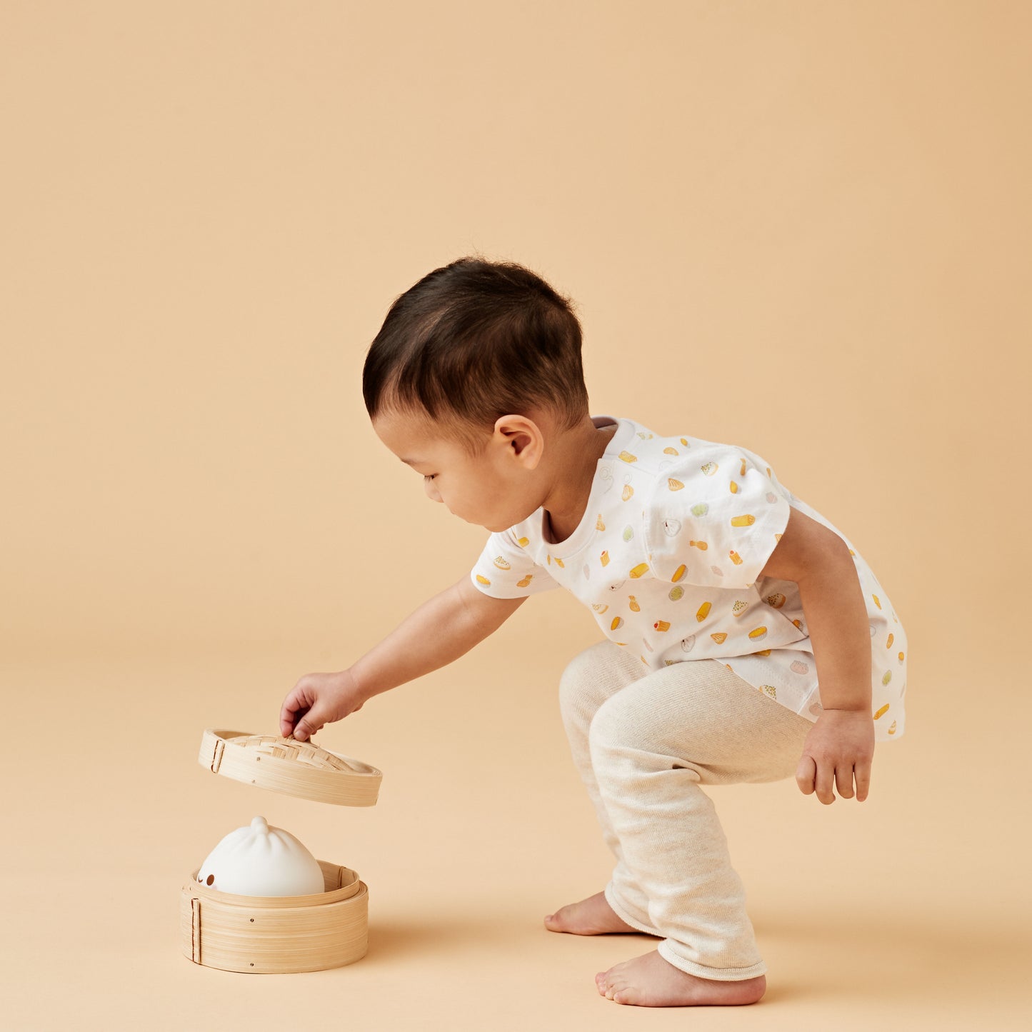 Boy wearing a colourful Dim Sum kids tshirt with a steamer bun basket