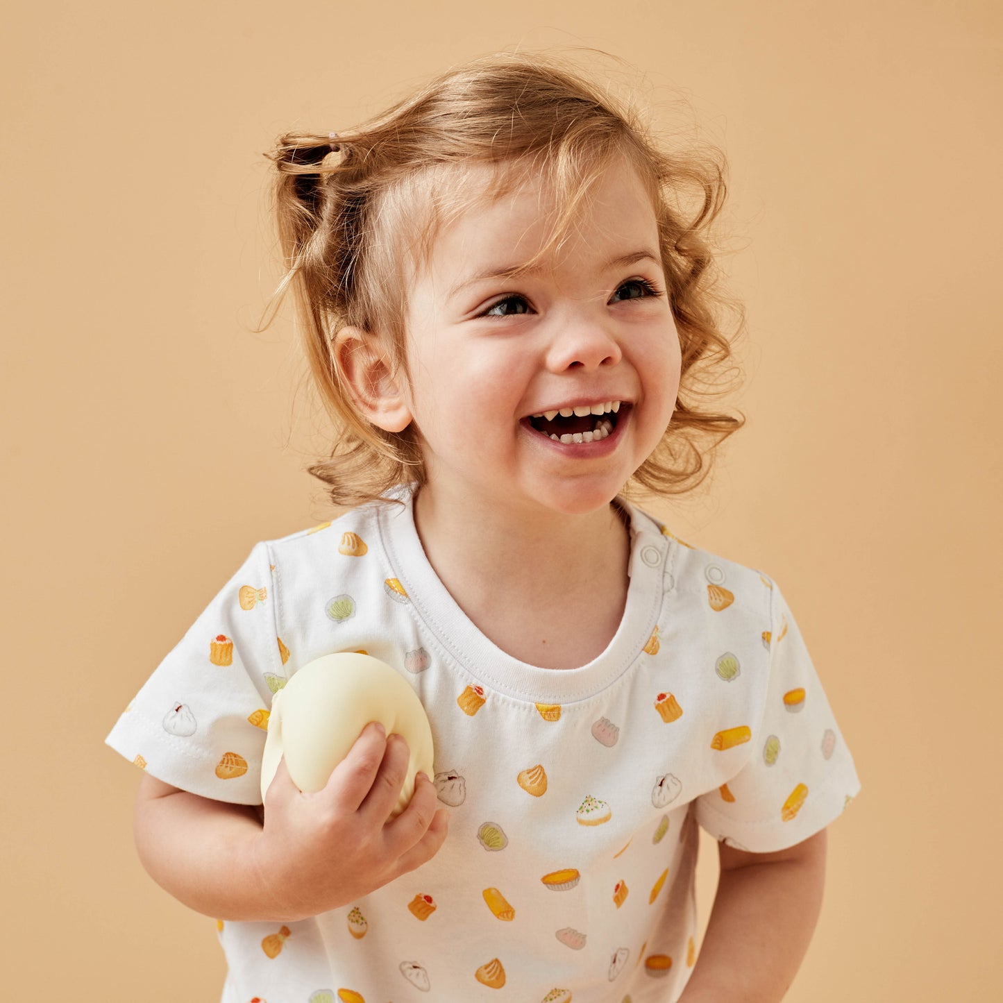 Girl wearing a colourful Dim Sum kids tshirt with a steamer bun